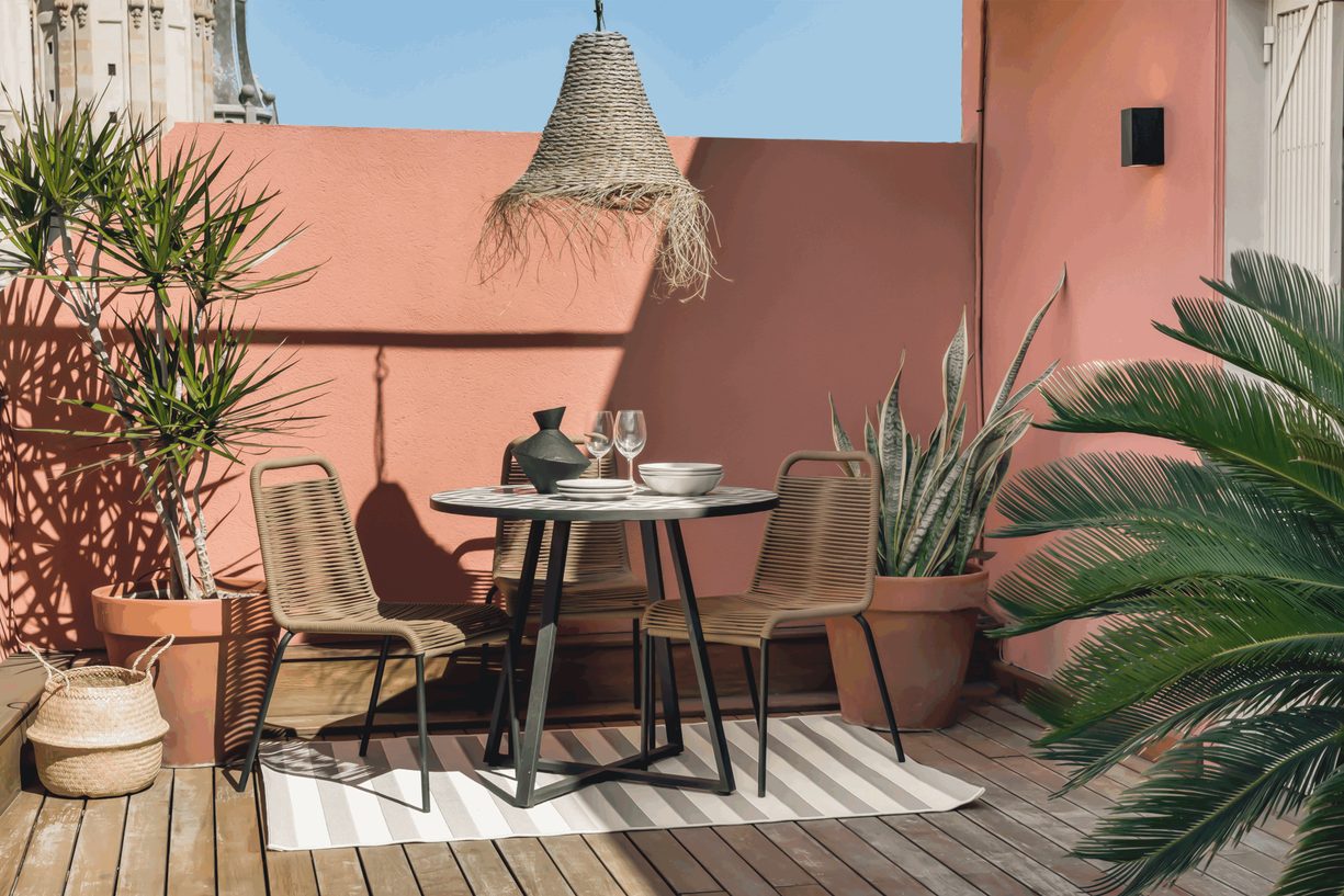 a patio with a table, chairs and potted plants. Have home, palm plants on terrace, terrace design, terracotta walls, beach lamps, zara home design, Noelle baartmans, Kelly wearstler, VT wonen, Aptó interiors