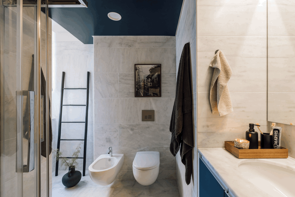 a bathroom with blue walls and a ladder. Painted ceiling, marble walls and floors, bathroom decoration, interior staging. Bathroom vase. Bathroom towels. Zara home setting. by Aptó interiors Kelly Wearstler, Noelle Baartmans 