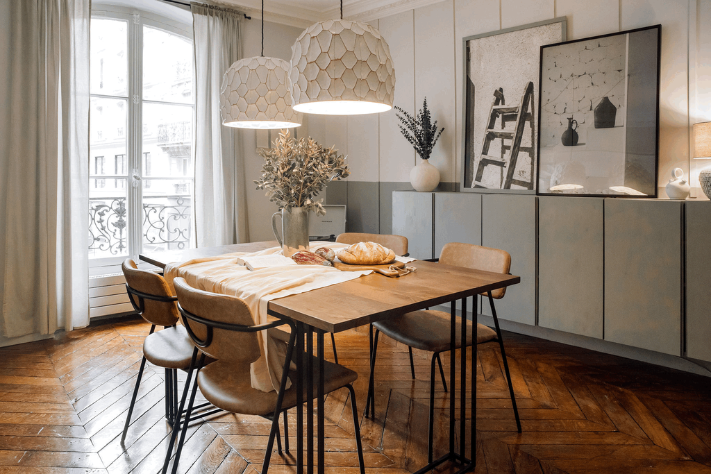 a dining room with a table and chairs in front of a window. Big wall decoration frames, black and white pictures. Organic home design, Ivar ikea, zara home, sklum, Noelle Baartmans by Aptó interiors